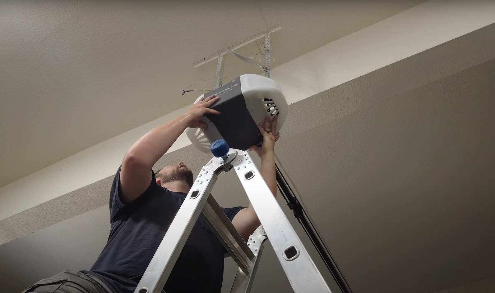 A garage door technician from Garage Door Repair Miami Gardens LLC inspecting a garage door opener affected by weather conditions like humidity and storms.