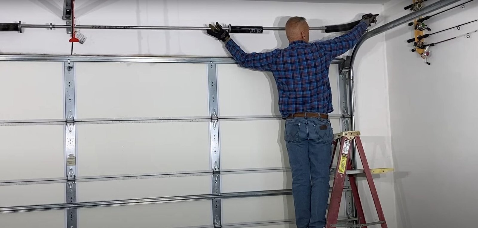 Close-up of a professional from Garage Door Repair Miami Gardens LLC inspecting a garage door spring for proper maintenance and repair
