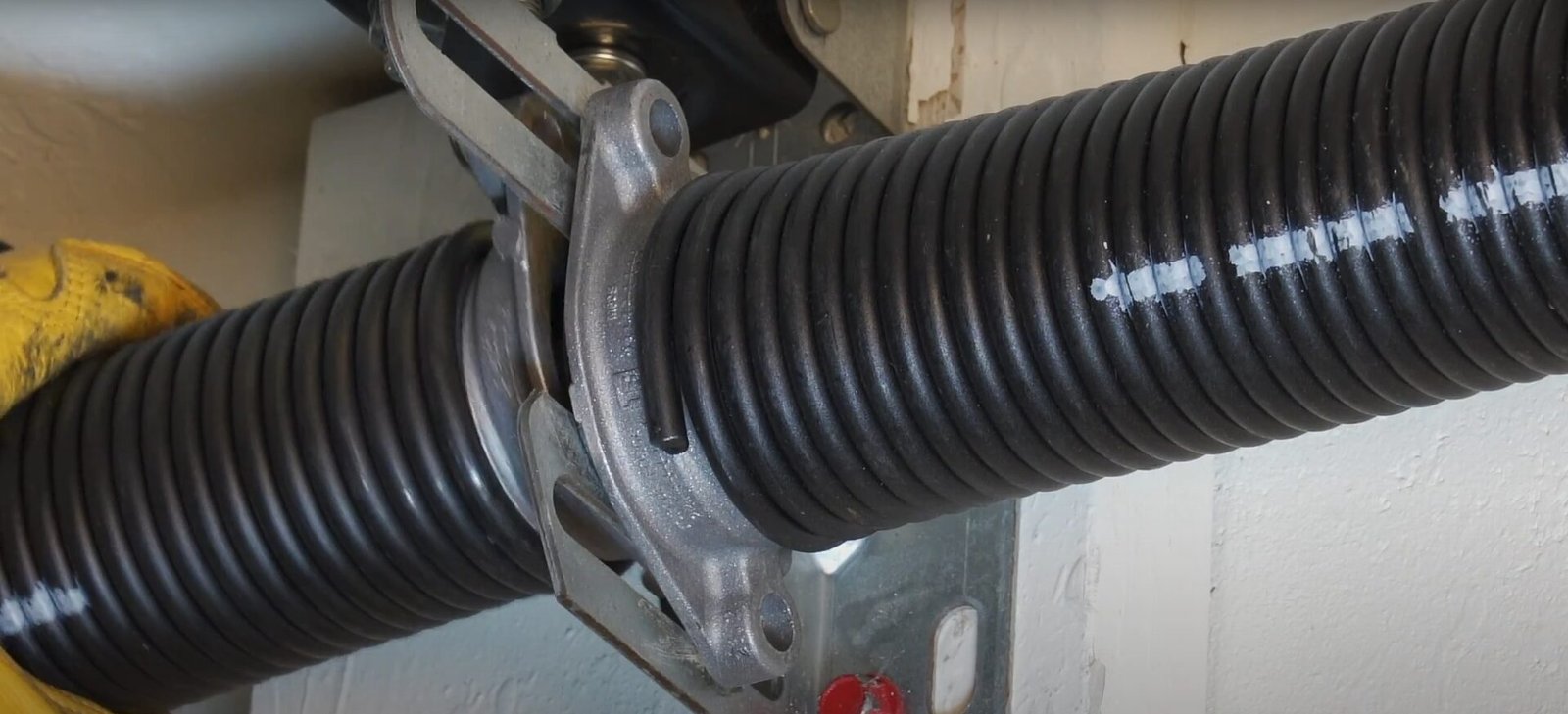 Professional technician from Garage Door Repair Miami Gardens LLC inspecting a garage door spring for timely repair to prevent safety risks