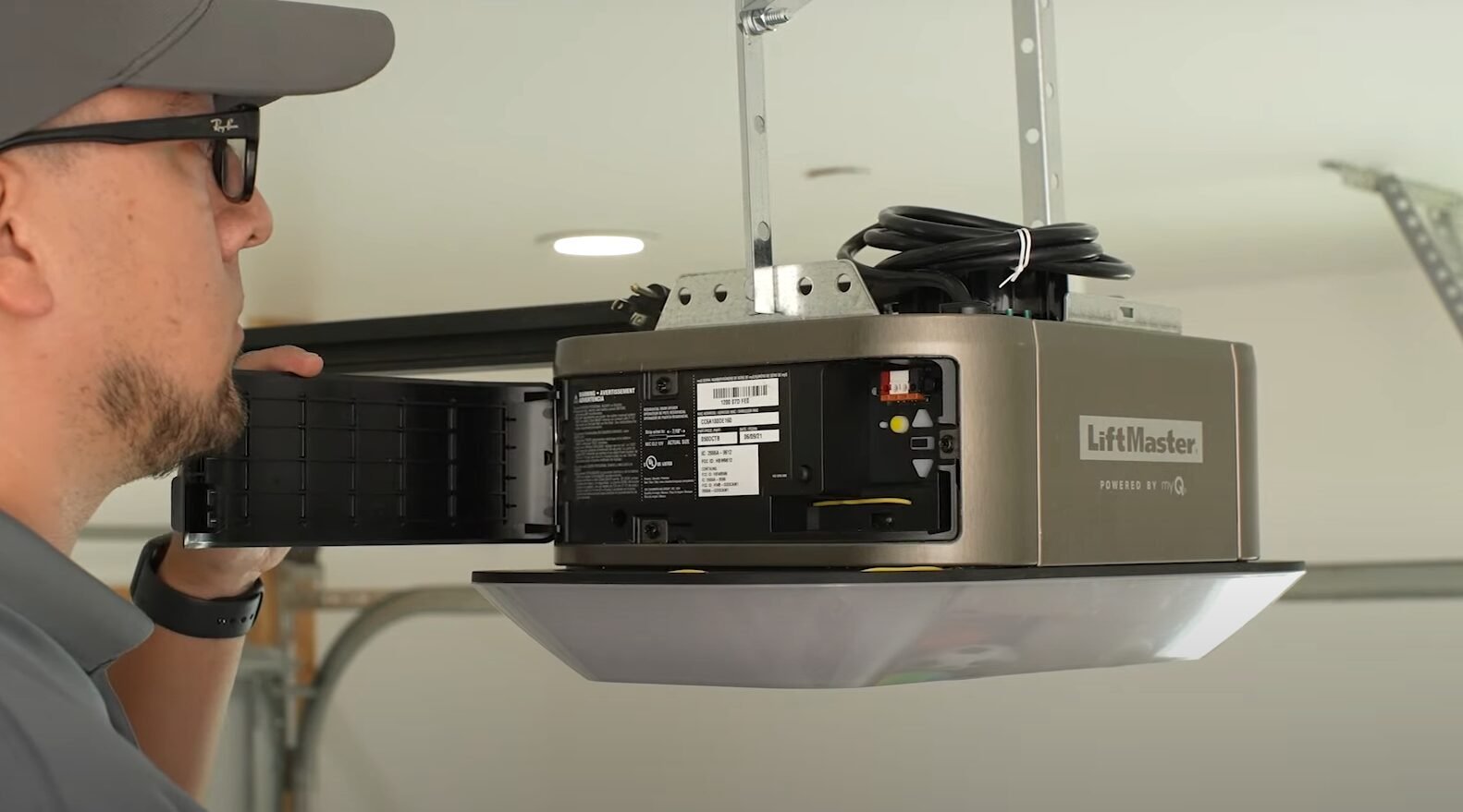 A technician from Garage Door Repair Miami Gardens LLC inspecting a garage door opener for immediate repairs to enhance safety and performance.
